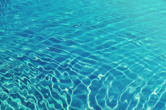 Sunlight rippling across blue swimming pool water